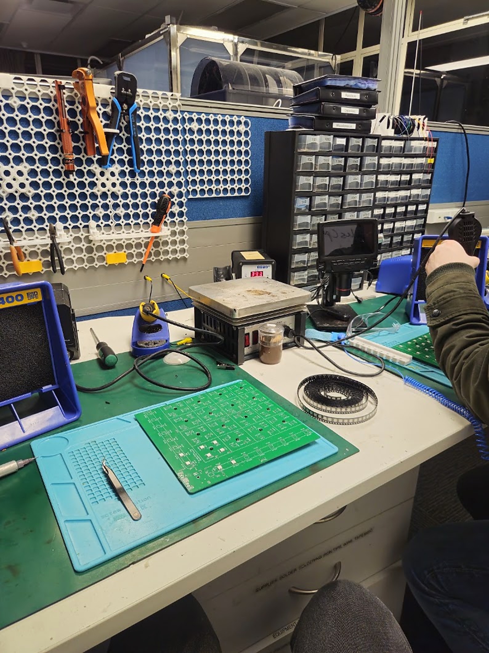 An SMD soldering bench with a hot plate, microscope, and the bare PCB